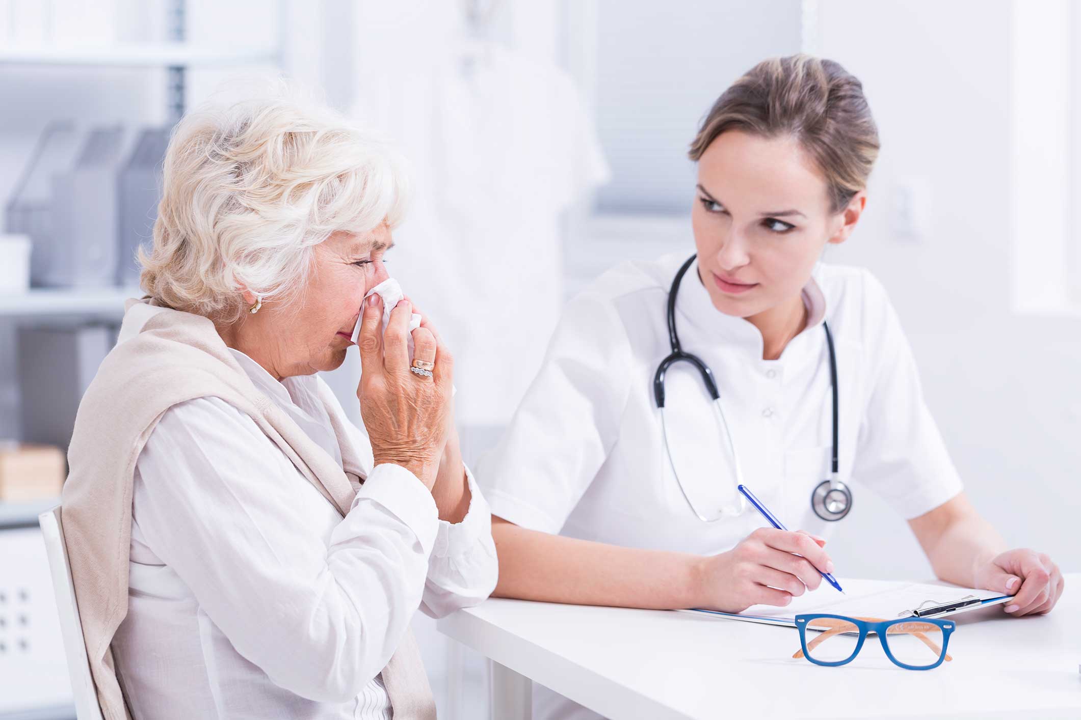 Woman blowing her nose because of her allergies