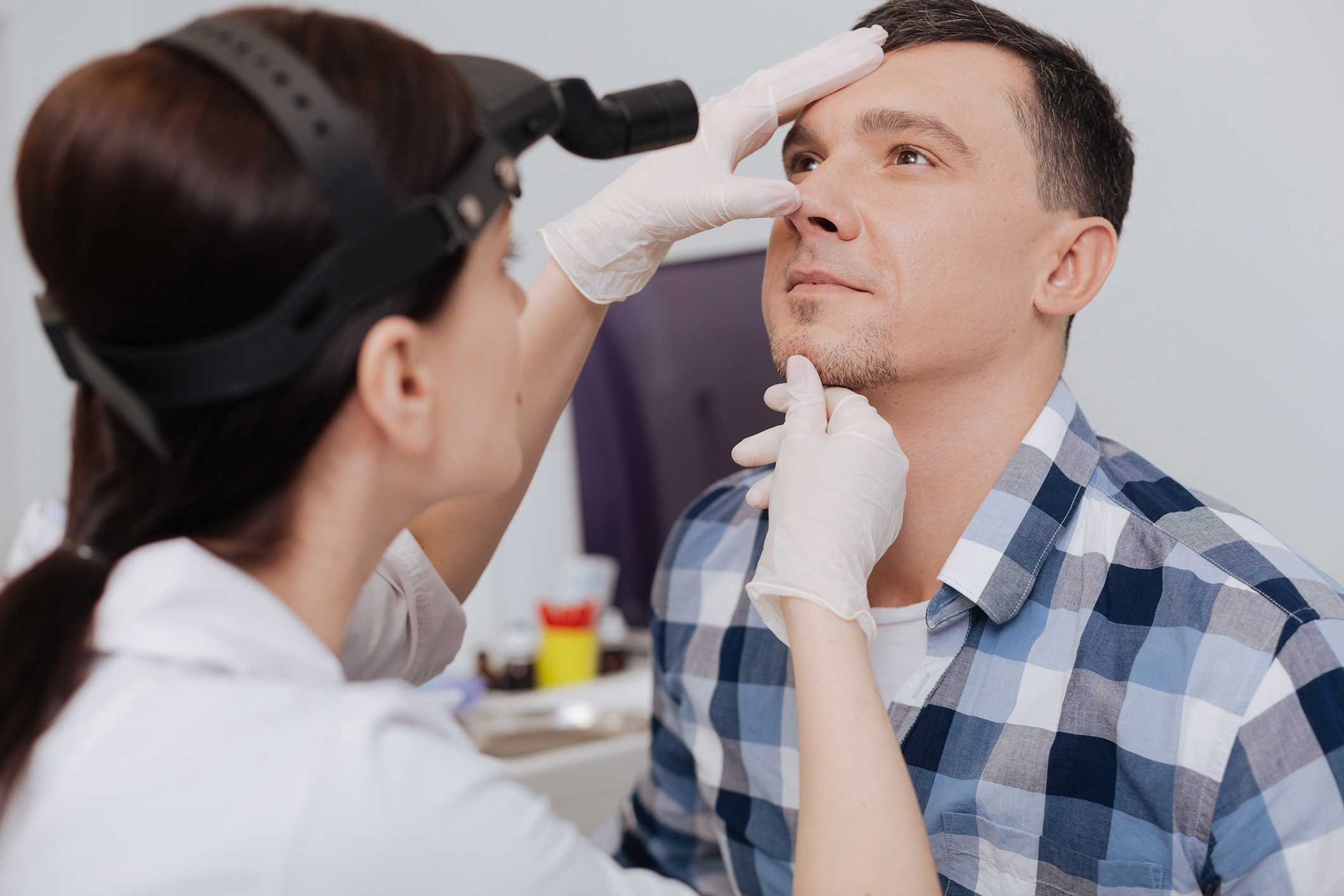 Doctor examining a man's nose