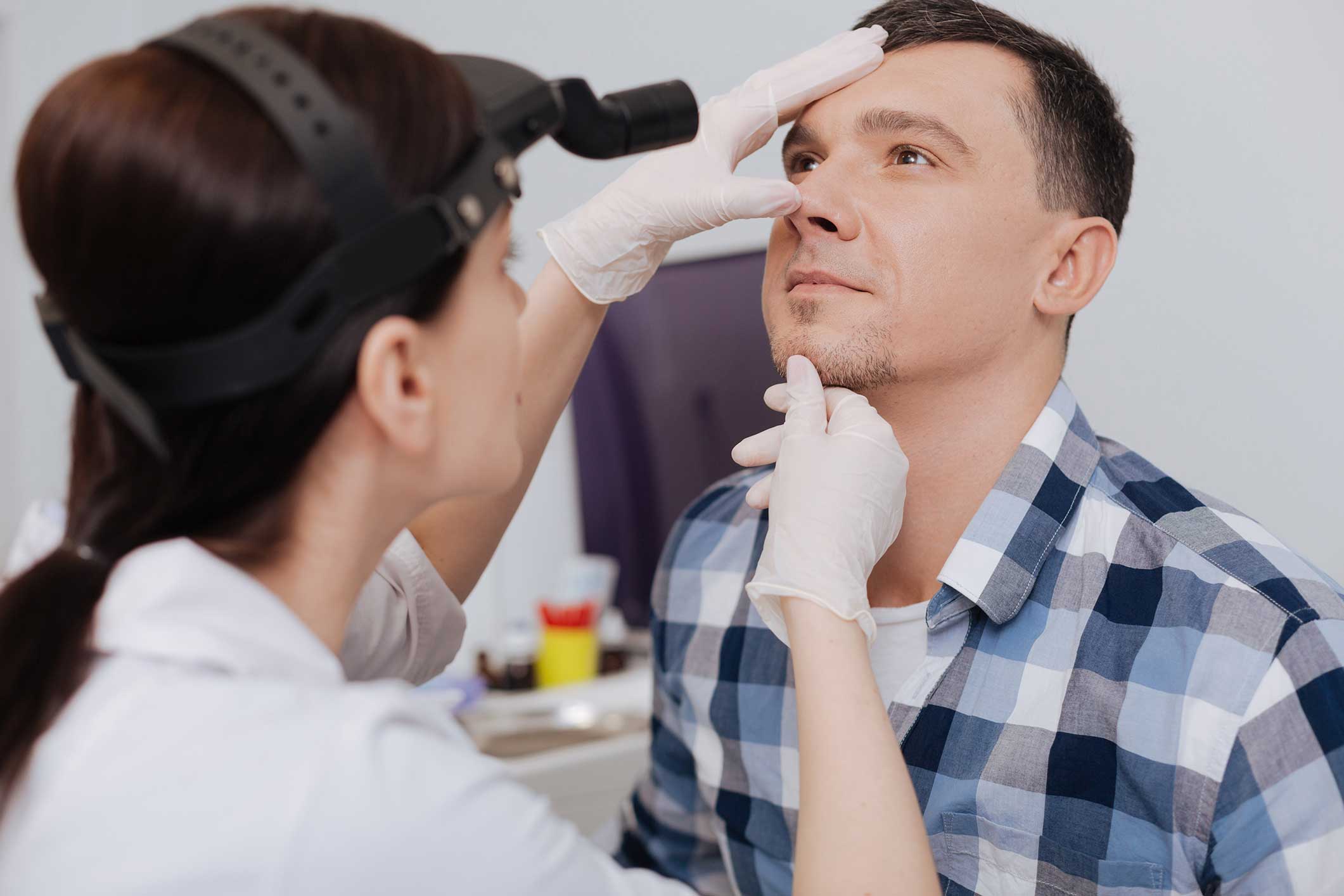 Doctor examining a man's nose for a deviated septum