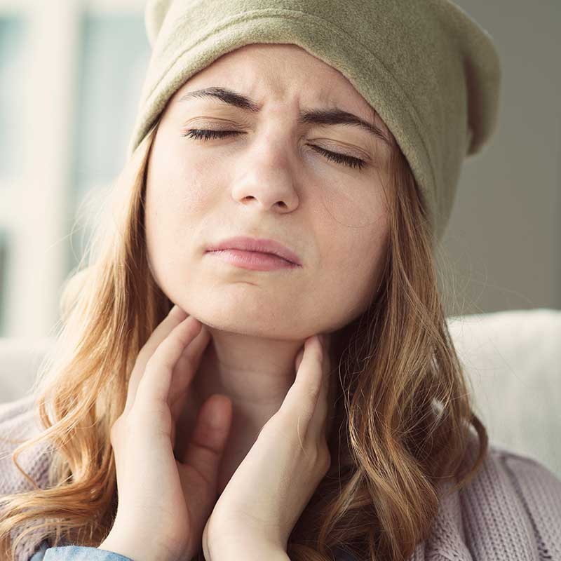 Woman holding her throat and wondering if she has a salivary gland disorder.