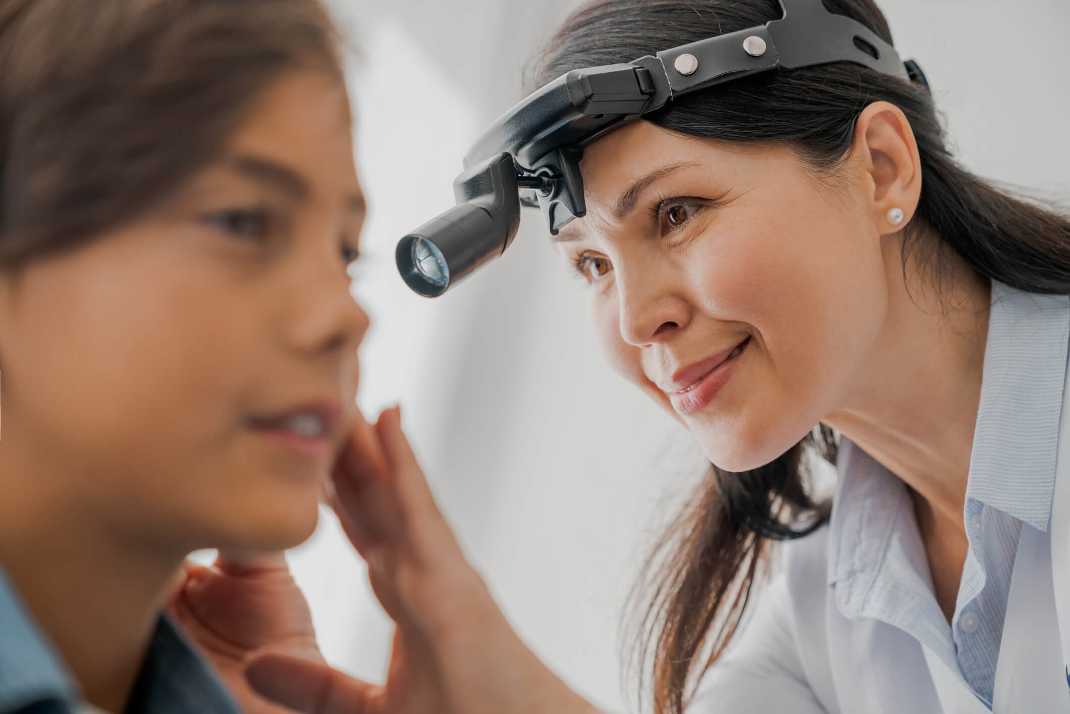 Doctor checking a young girl's ears for an ear infection